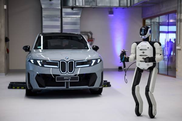 Aeon humanoid robot working on a vehicle assembly line at a BMW factory.