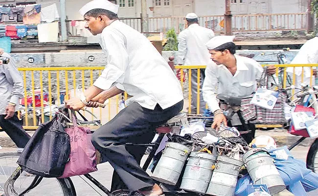Mumbai dabbawalas transporting lunchboxes through suburban railway network