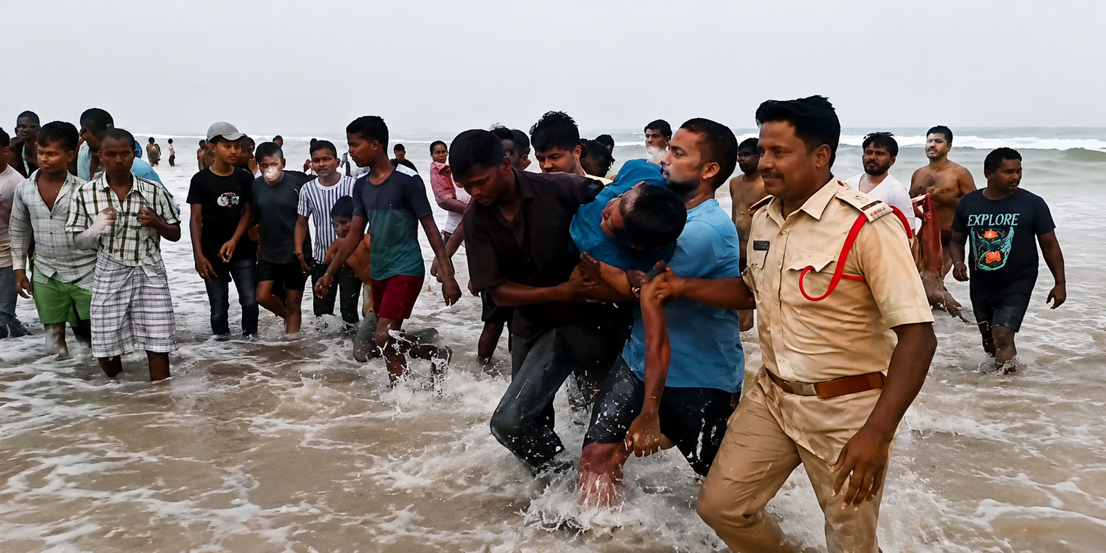 Marine police rescuing a teenage boy from strong sea waves near Chirala coast