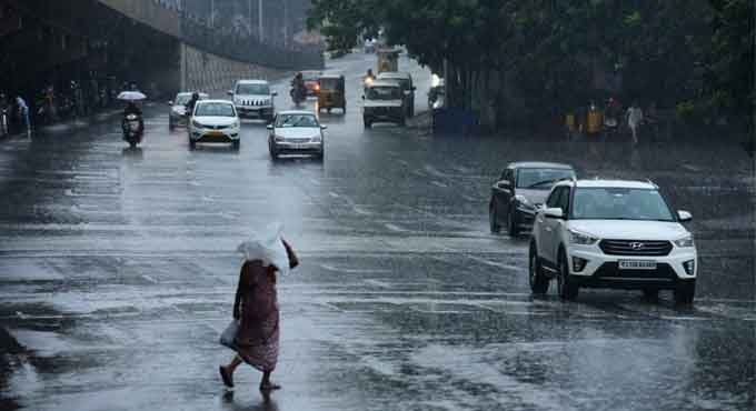 Rain-soaked road under cloudy skies in Hyderabad.