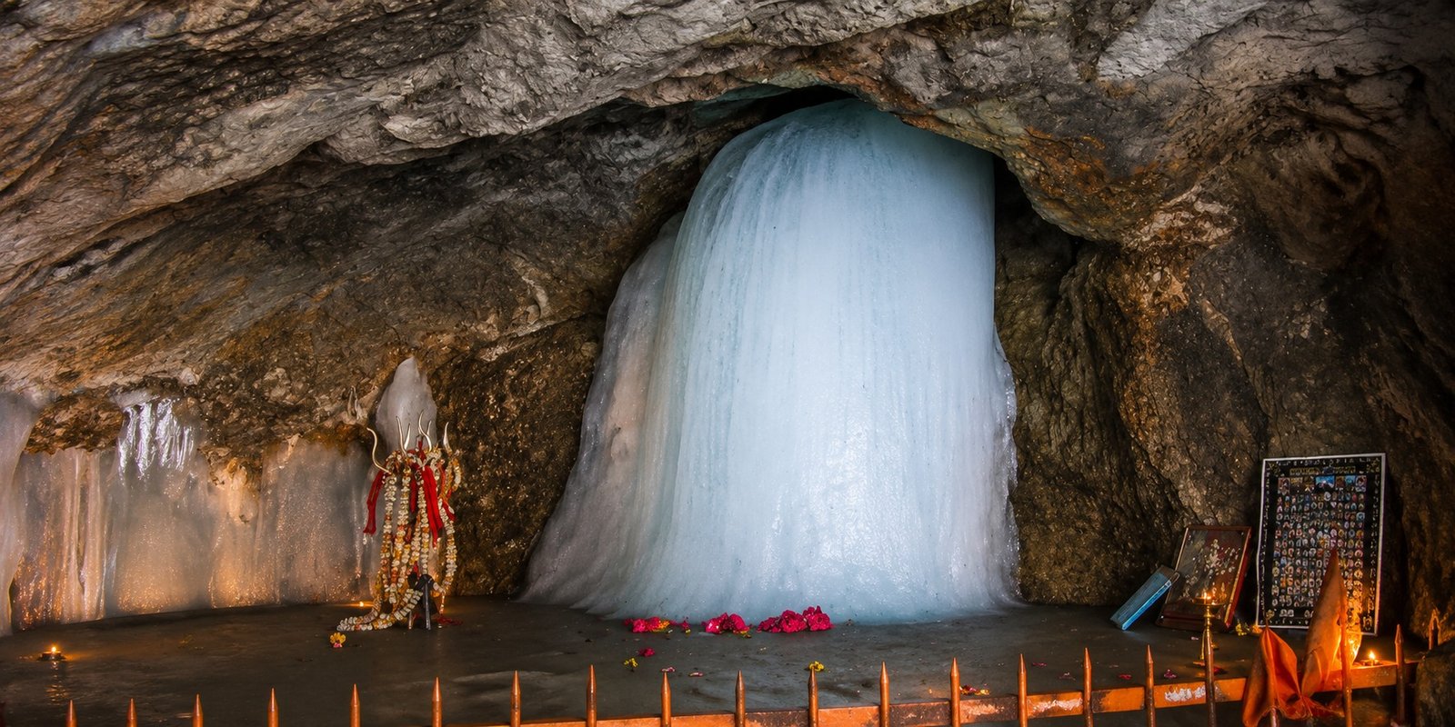 Amarnath cave with melting natural Ice Shivling and devotees.