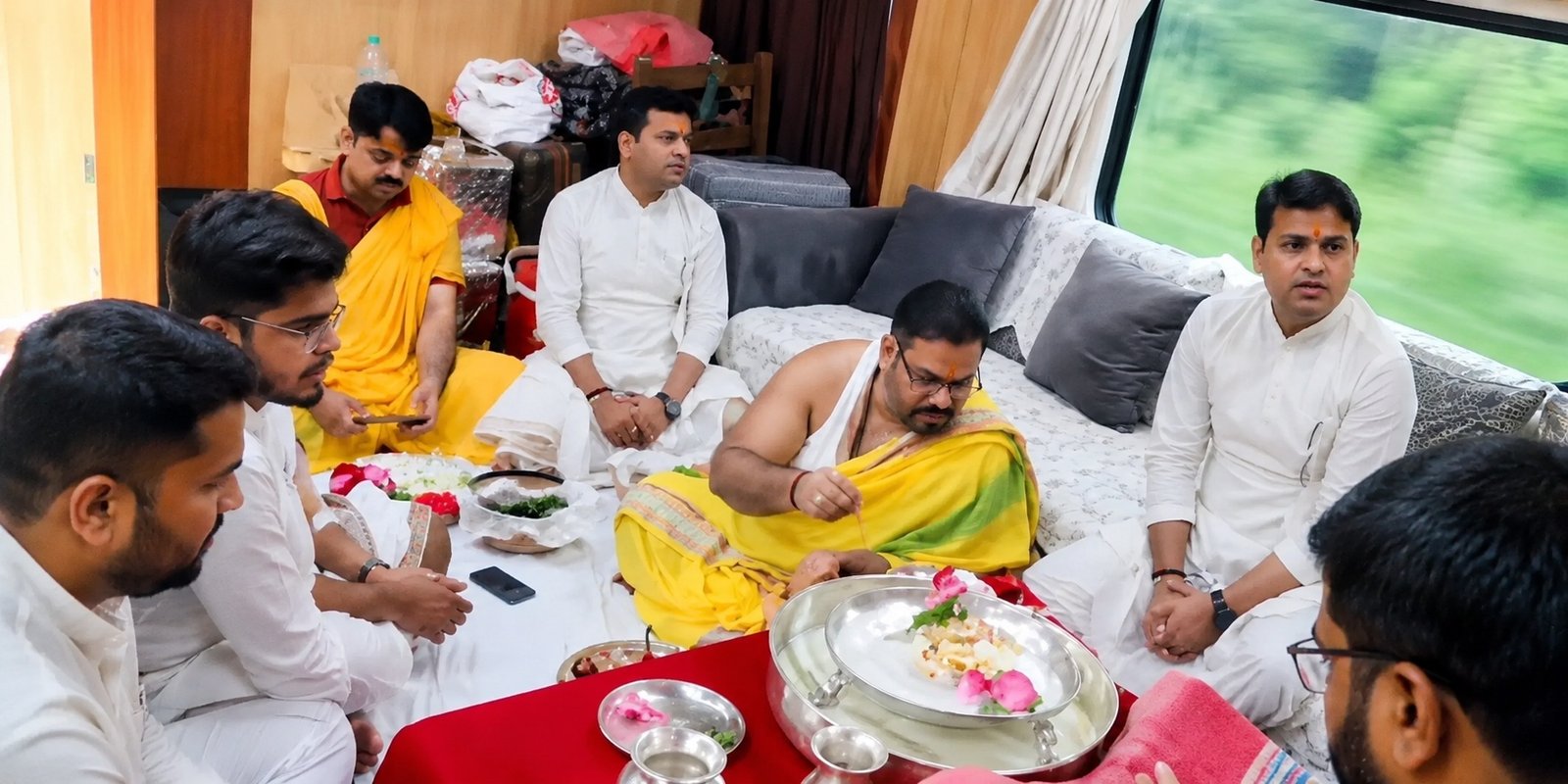 Devotees performing a Hindu puja inside a privately booked railway saloon coach.