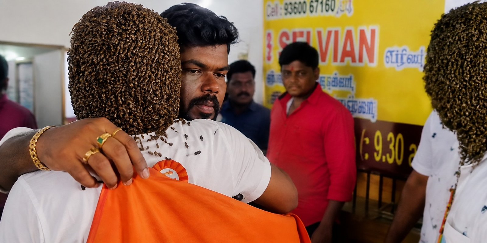 Murugan stands with his face covered by Indian bees