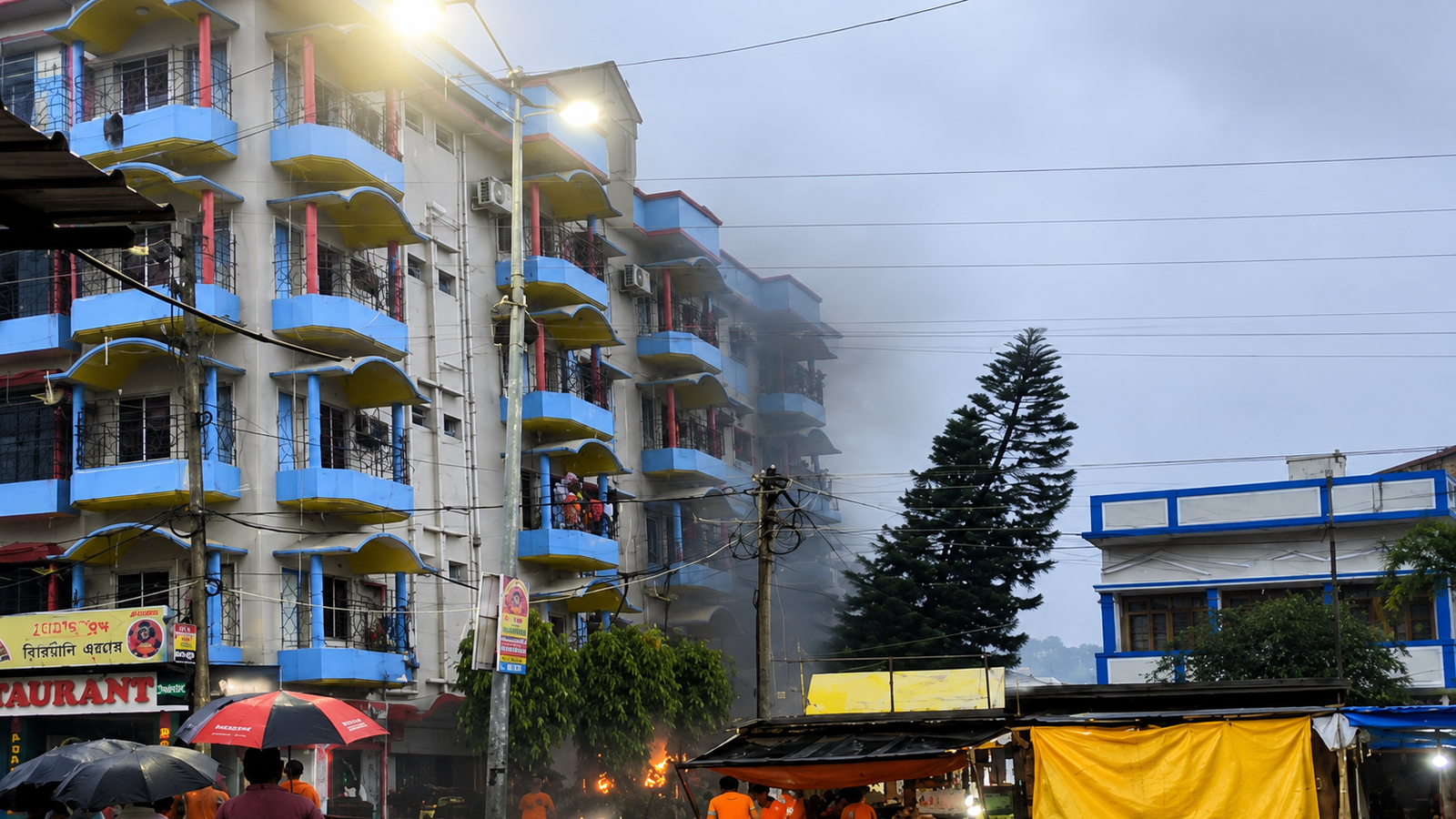Firefighters inspect the Tarapith hotel fire site