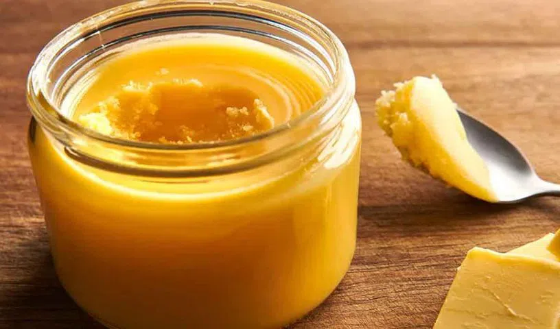 A spoon of ghee served with traditional Indian food.