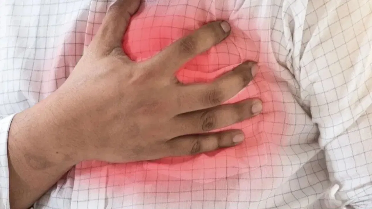 Person experiencing heart attack symptoms while alone at home.