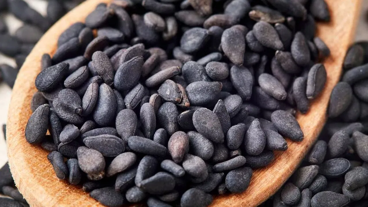 Black sesame seeds in a bowl with healthy food ingredients