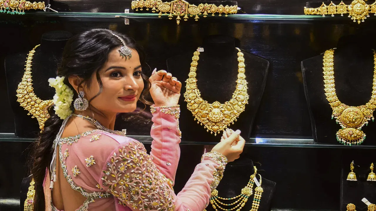 Gold jewellery displayed beside gold price information in India.