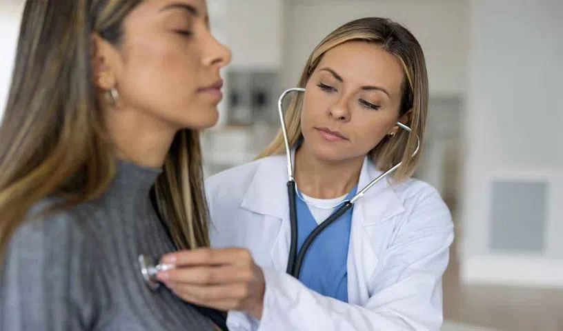 Doctor checking a patient’s heart with a stethoscope.