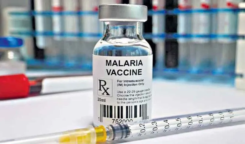 Healthcare worker preparing a malaria vaccine dose for a child.